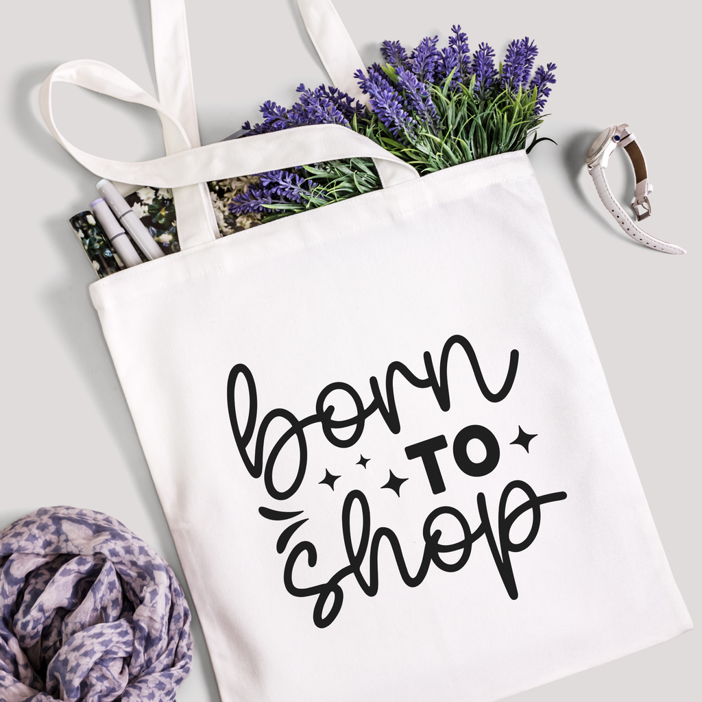 Born To Shop tote filled with lavender stems and marker pens, leopard-print scarf below
