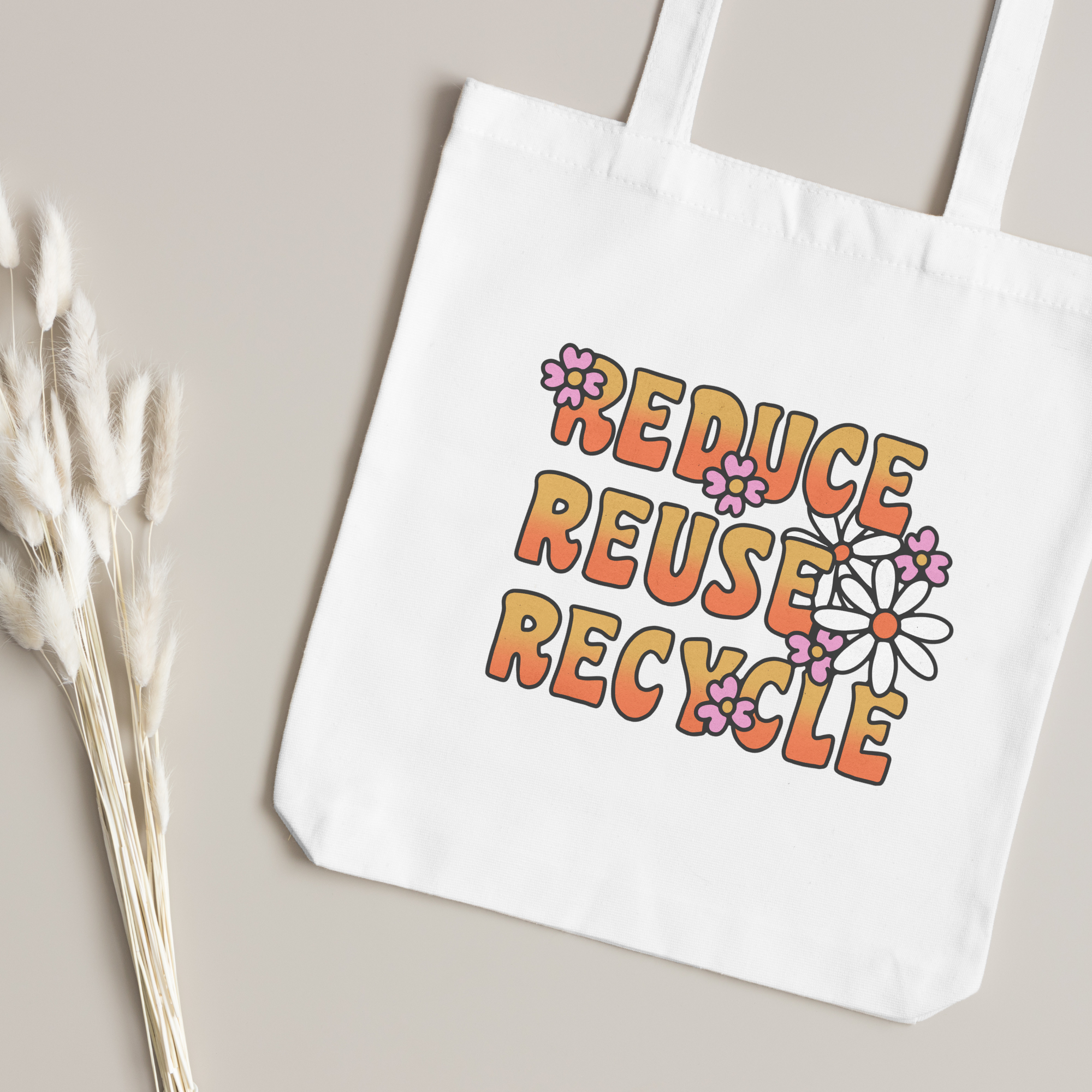 Orange lettering and daisy print close up, dried bunny-tail grass on a taupe surface
