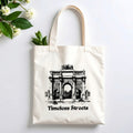 Plovera Co Timeless Streets tote laid flat on pale grey with white blossom and green leaves