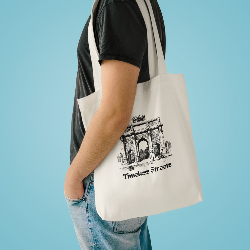 Timeless Streets tote over the shoulder of a person in a charcoal tee against pale blue