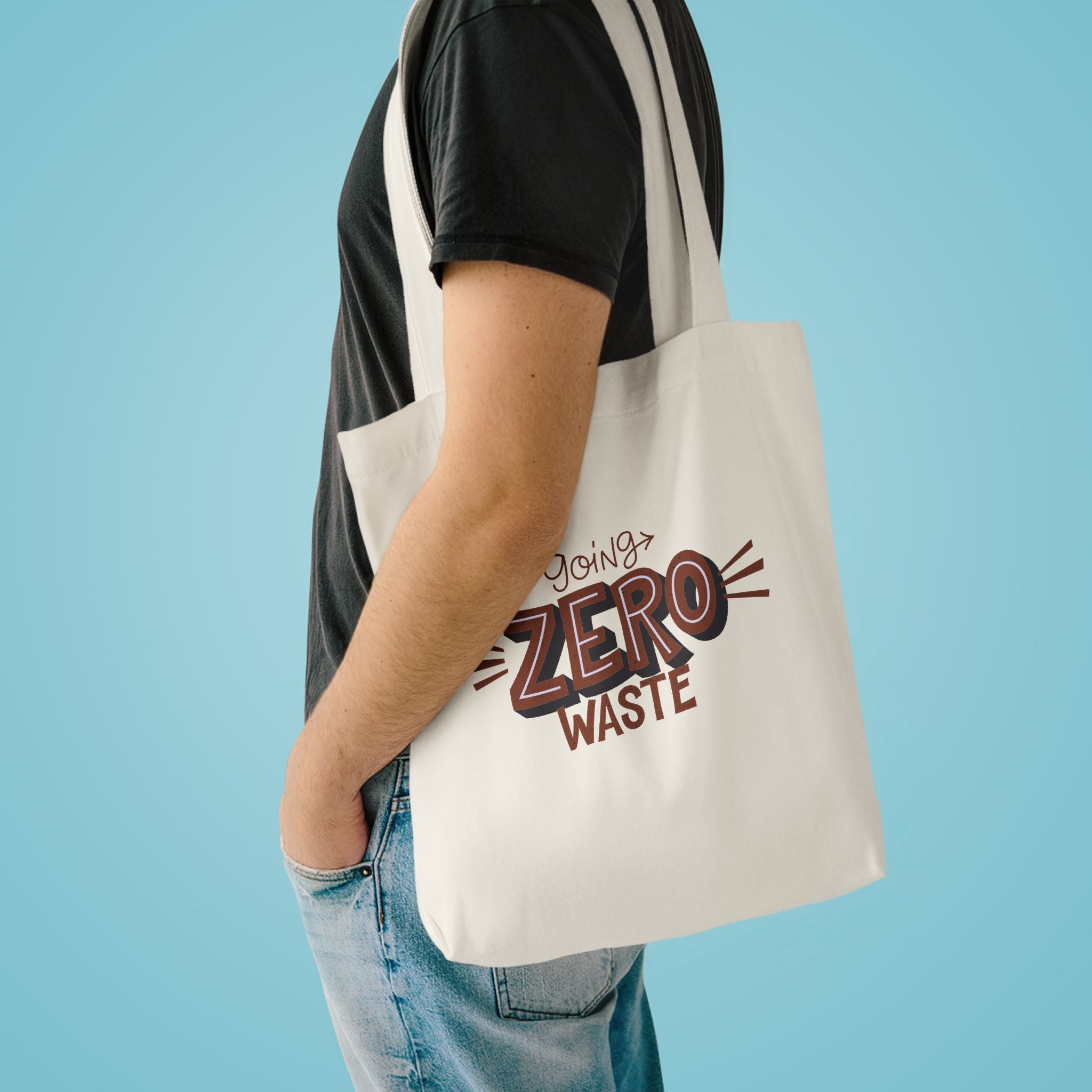 Going Zero Waste tote over the shoulder of a person in a charcoal tee against pale blue