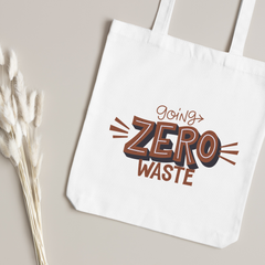 Rust and navy Going Zero Waste lettering close up, dried bunny-tail grass on a taupe surface
